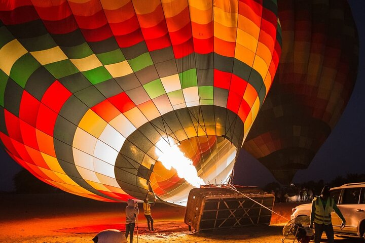 Sail high above the stunning Dubai desert experiencing the serene beauty of the landscape as colorful hot air balloons gracefully rise creating unforgettable memories for every adventurer.